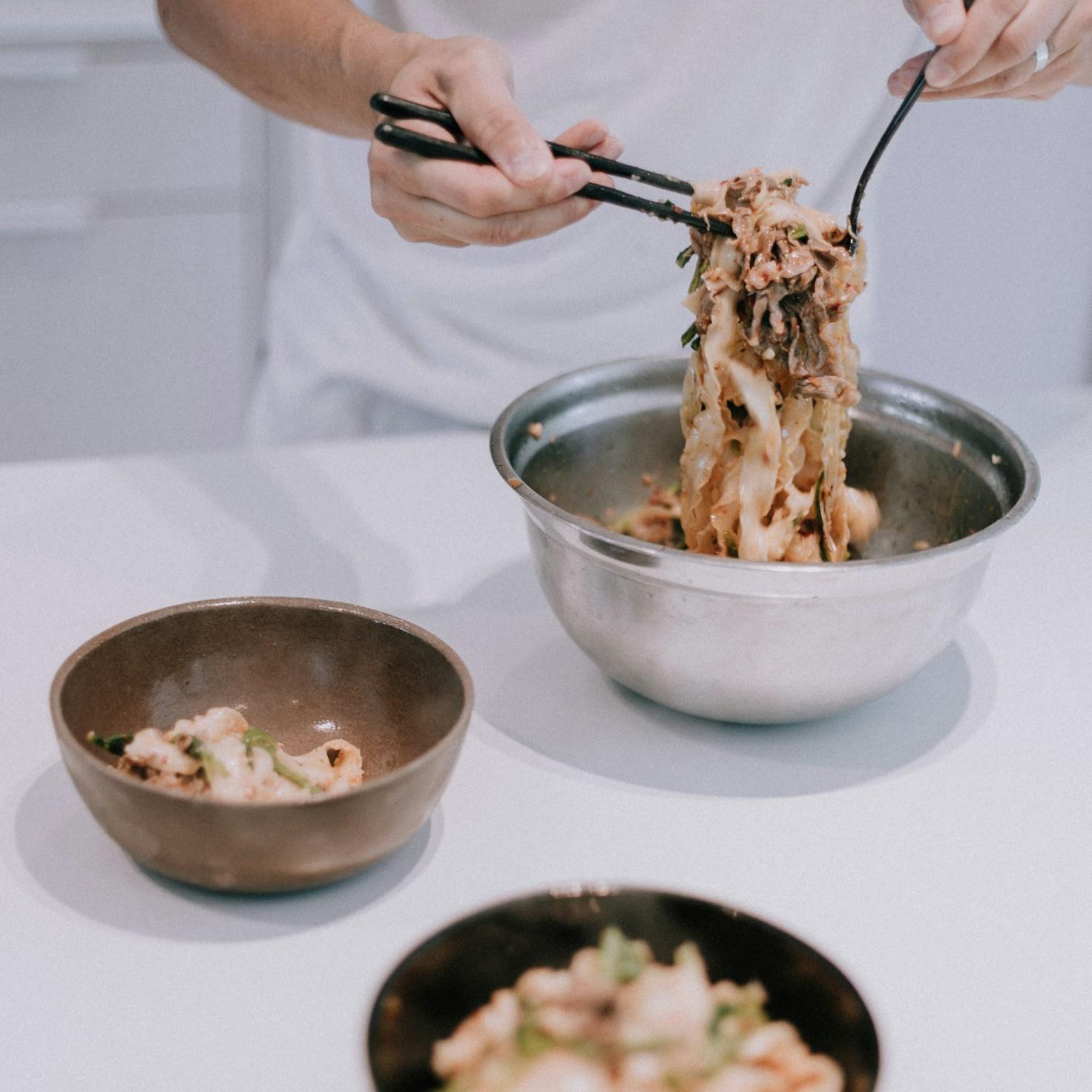 Community members cooking together in a contemporary kitchen, swapping recipes and techniques